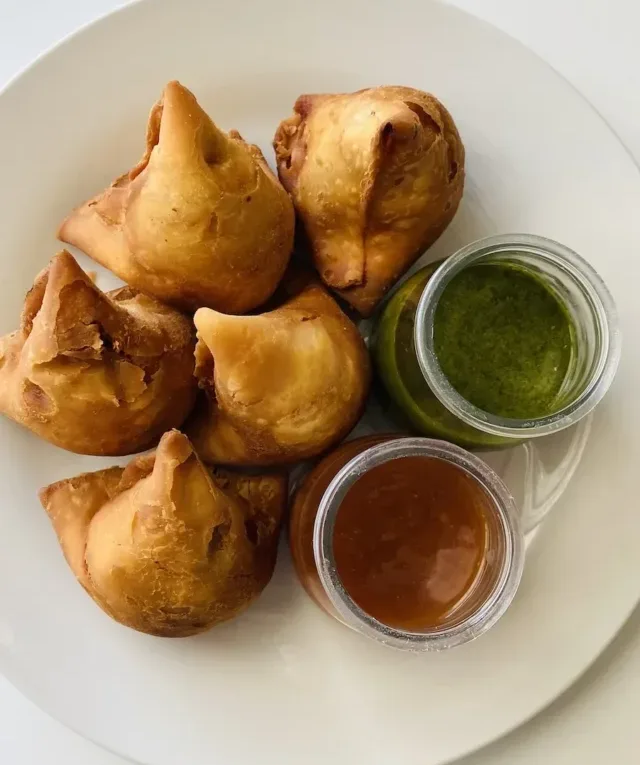 Crunchy Samosa with chutney over a Ceramic Plate