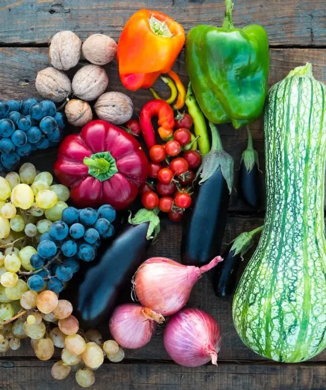 a variety of fruits and vegetables on a wooden surface