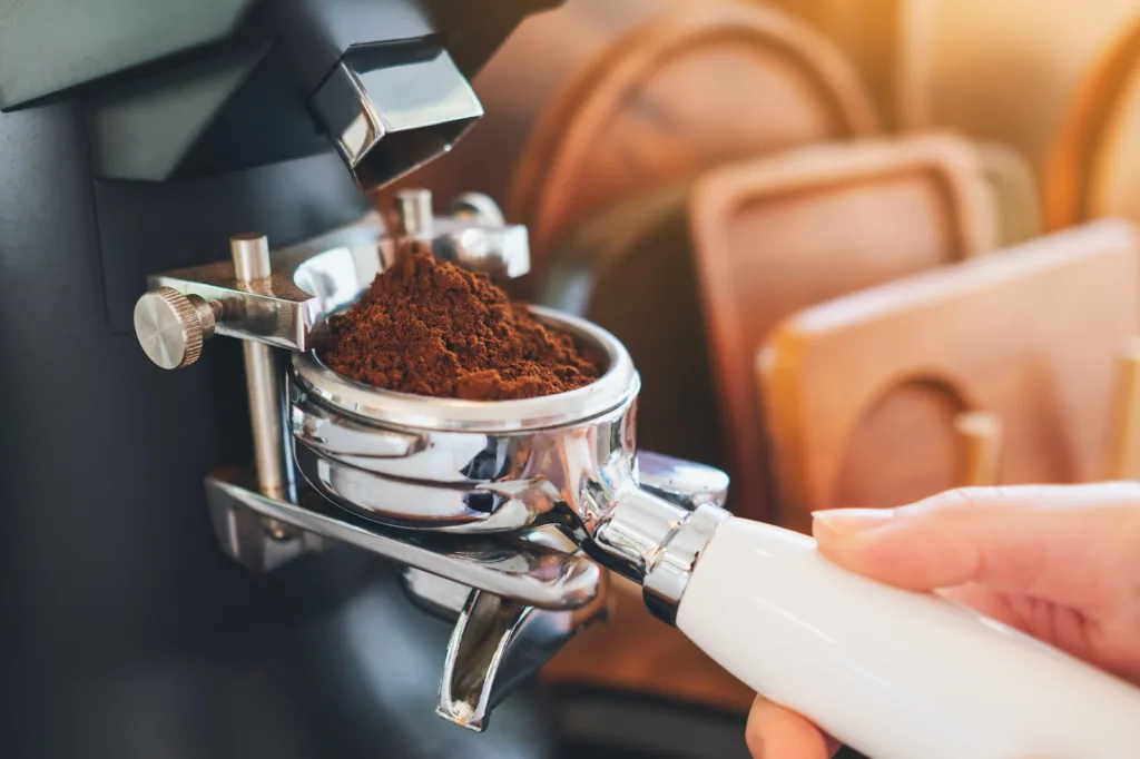 person pouring fresh coffee on silver cup