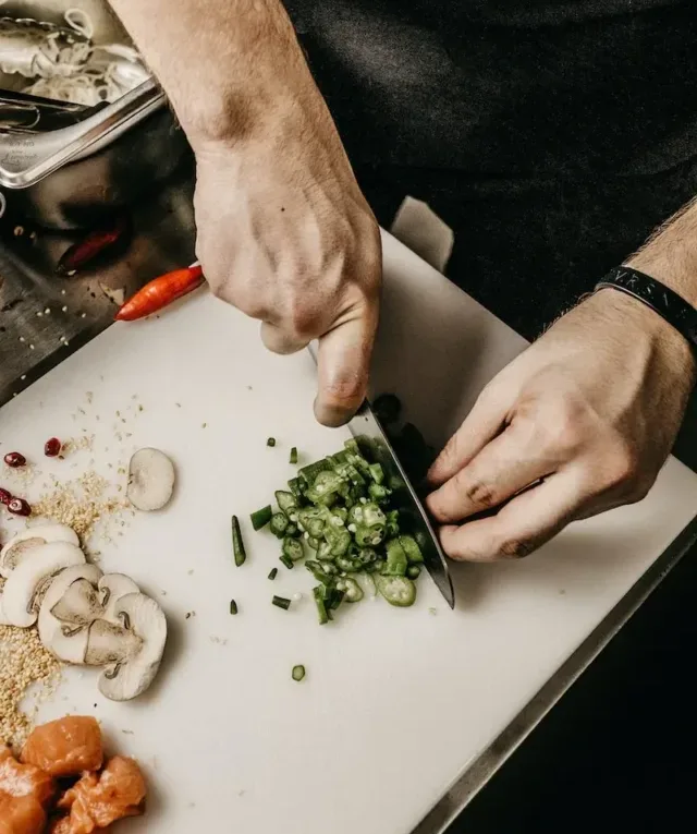 person slicing vegetable