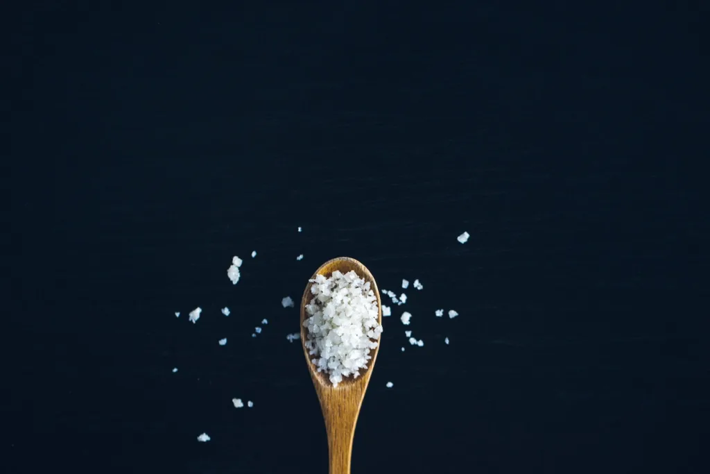 brown wooden spoon full of salt