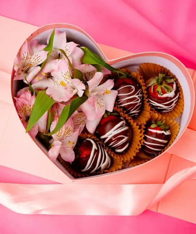 a heart shaped box filled with chocolate covered strawberries